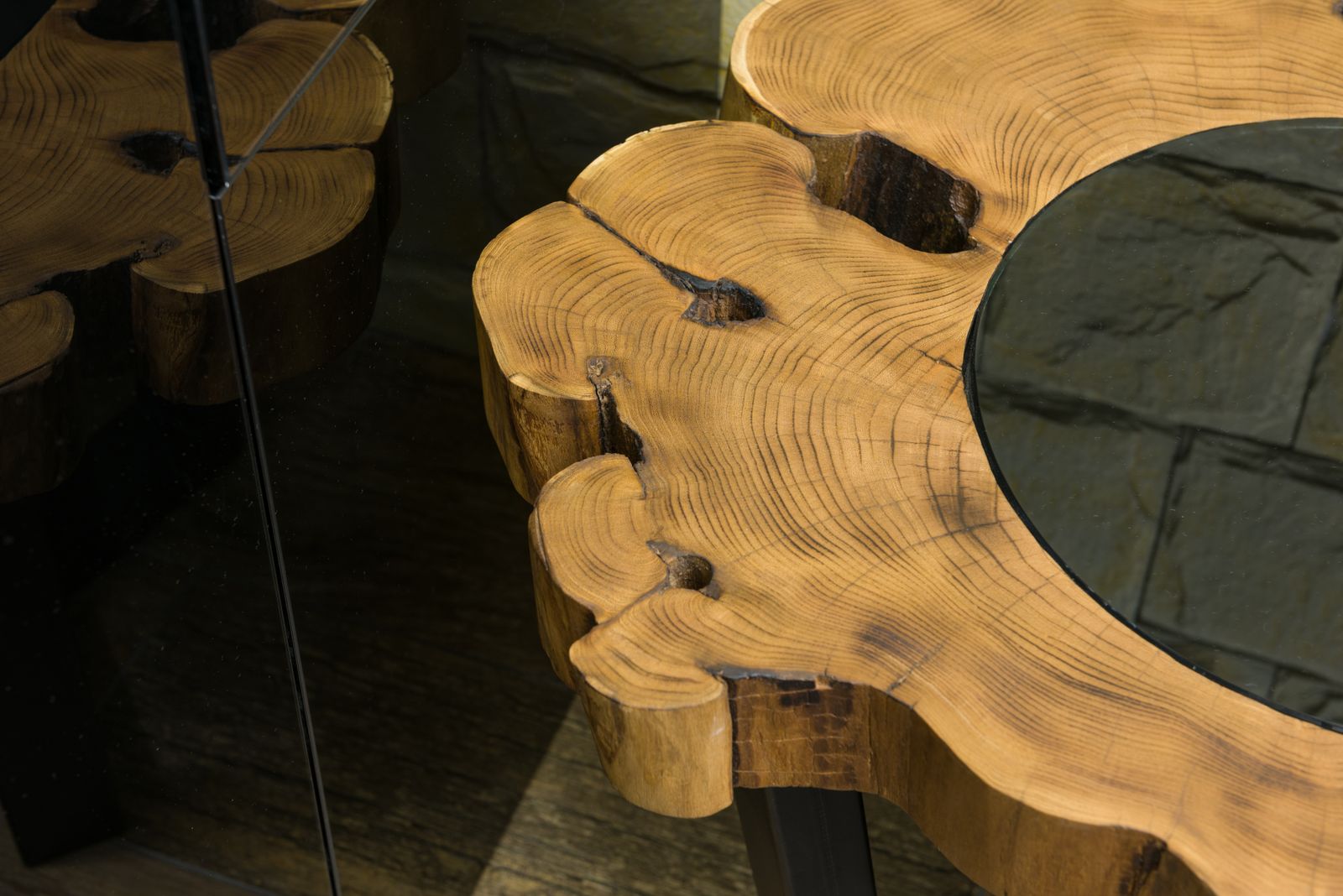 A live-edge slab coffee table with a smoked-glass inlay, rings of grain showing